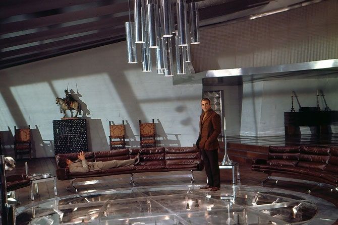 a man standing in front of a circular glass table