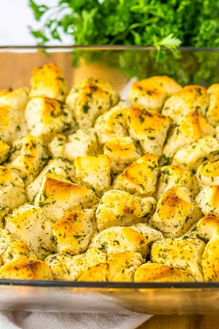 a glass casserole dish filled with chicken and cheese, garnished with parsley