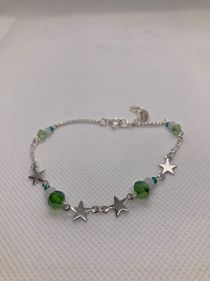 This is a sterling silver bracelet. It has 4 stars. The colors are light green and a white jade gemstone. Green Nickel Free Bracelets With Round Beads, Silver Bangle Bracelet For May Birthstone, Nickel-free Green Beaded Bracelets As A Gift, Nickel-free Green Beaded Bracelets For Gift, Green Nickel-free Beaded Bracelets As A Gift, Nickel-free Green Beaded Bracelet For Gift, Silver Sterling Bracelets For May Birthstone, Adjustable Silver Jade Crystal Bracelet, Silver Sterling Bracelet For May Birthstone