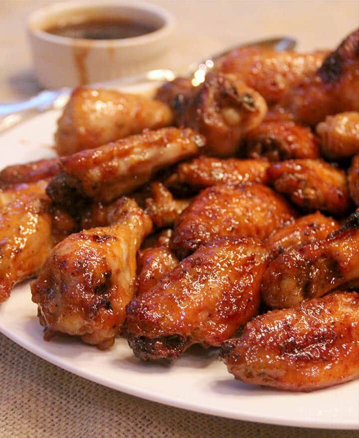 honey garlic sriraca baked wings on a white plate