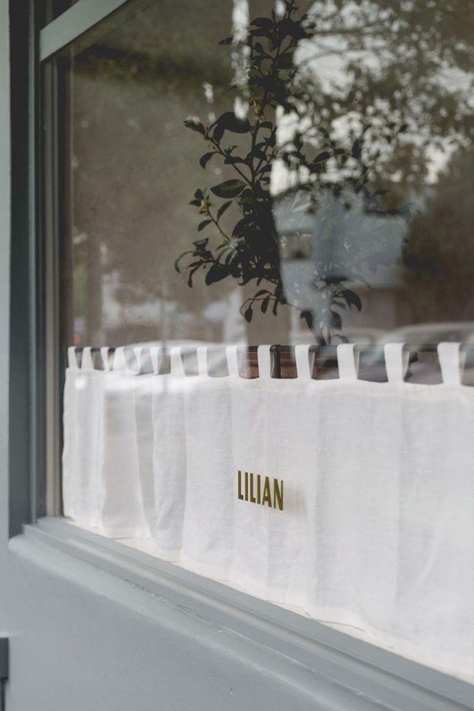 there is a white table cloth with the name lulian on it in front of a window