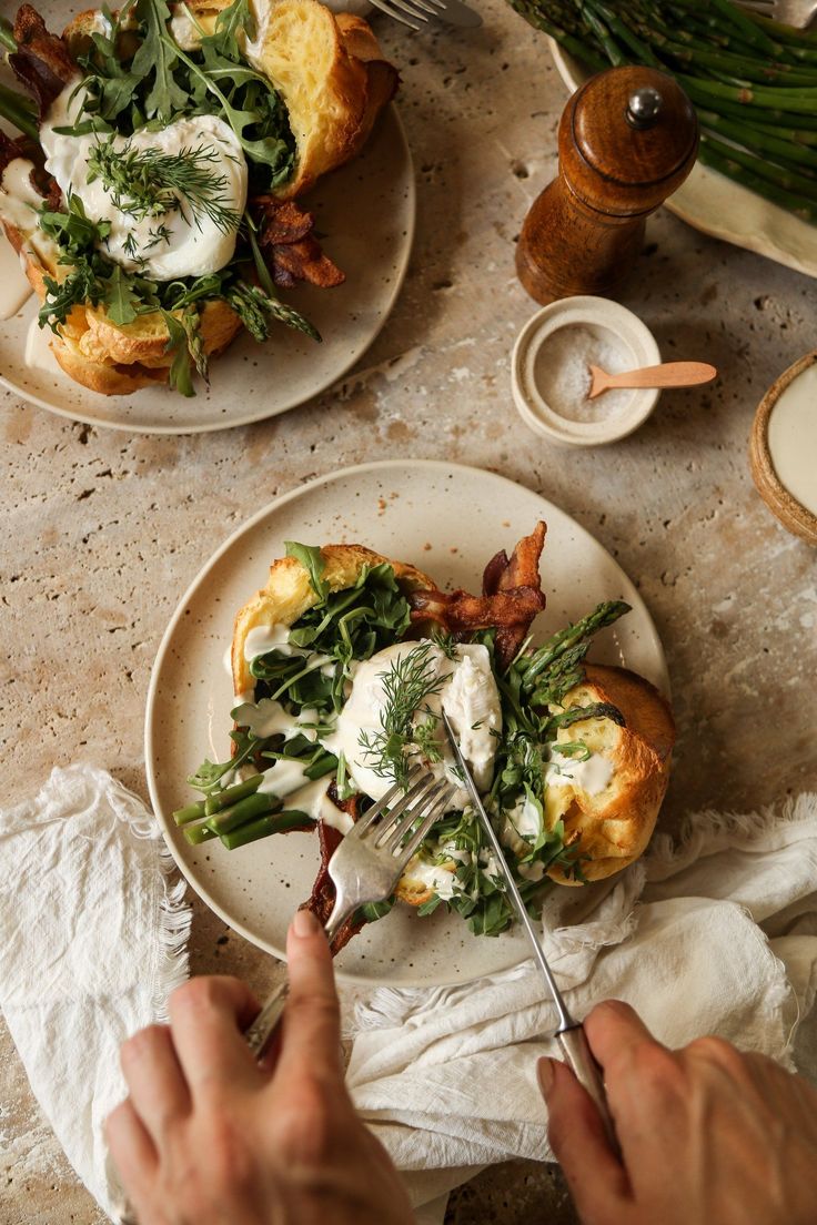 two plates with food on them sitting on a table next to utensils and napkins