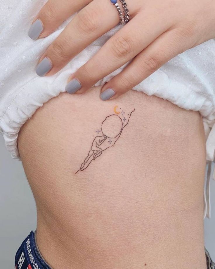 a woman's stomach with a small tattoo on the side of her belly,