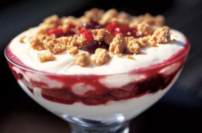 a dessert in a glass dish with crumbled toppings on top, sitting on a table