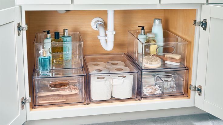 an organized bathroom cabinet with toiletries and other items in it, including rolls of toilet paper