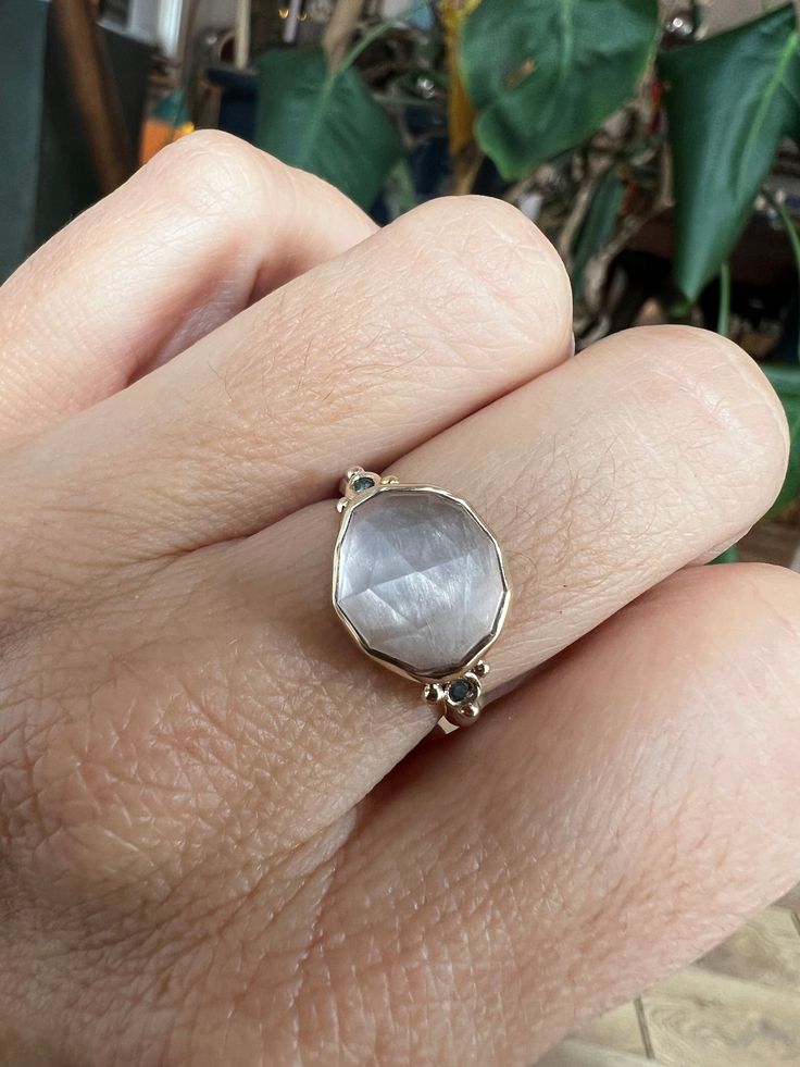 A freeform Evil Eye shaped Rose Quartz is sweet with a little edge. Accented by pale green sapphires set atop our hand sculpted sterling silver band. Approximate stone size: 15mm x 12mm Approximate stone weight: 5 cts Mohs Hardness scale: 7 This one of a kind piece is handmade with love in Emily's Hudson Valley studio. If you have questions about sizing, shipping or need help deciding on your perfect piece please reach out to us! Yellow Gold Oval Moonstone Ring In Sterling Silver, Oval Moonstone Ring In Yellow Gold Sterling Silver, Heirloom Moonstone Ring With Rose Cut Diamonds For Promise, Heirloom Moonstone Ring With Rose Cut Diamonds, Rose Cut Diamond Moonstone Promise Ring, 14k Gold Moonstone Promise Ring With Rose Cut Diamonds, Promise Ring With Moonstone And Rose Cut Diamonds, Heirloom Style Moonstone Ring With Rose Cut Diamonds, Promise Ring With Rose Cut Diamonds And White Topaz