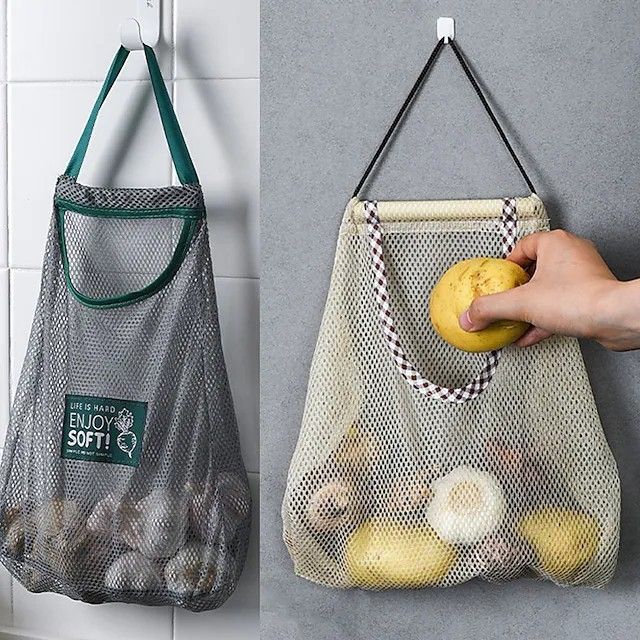 two bags hanging on the wall with food in them and one bag holding an apple