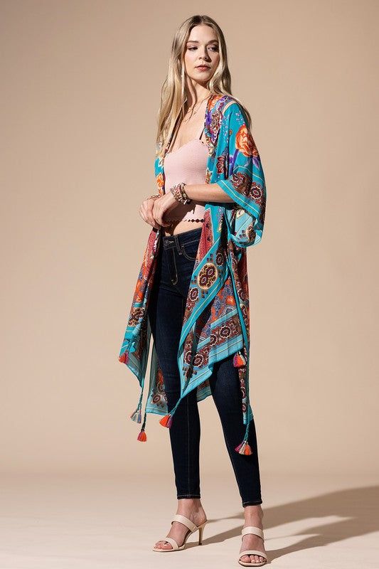 The bohemian wardrobe staple every woman needs! This stunning mixed floral print kimono features breezy side slits, half-length kimono sleeves, and a relaxed oversize fit. Throw it on at the beach for a quick cover-up or style it with your favorite jeans and a band tee for a cool everyday look. Mixed floral print Relaxed, oversize fit 1/2 length kimono sleeve Mid-length Side vents Open front Bohemian style One size fits most 100% Viscose Length: 38" Width: 40" Cover-up Bohemian Kimono With Boho Print For Beach Cover-up, Bohemian Multicolor Tassel Cover-up, Boho Print Cover-up With Kimono Sleeves For Beach Season, Open Front Beach Kimono With Tassels, Long Tasseled Kimono For Beach Cover-up, Long Tasseled Kimono For Vacation, Hippie Printed Kimono For Beach Cover-up, Bohemian Printed Kimono For Beach Cover-up, Open Front Kimono With Tassels For Beach