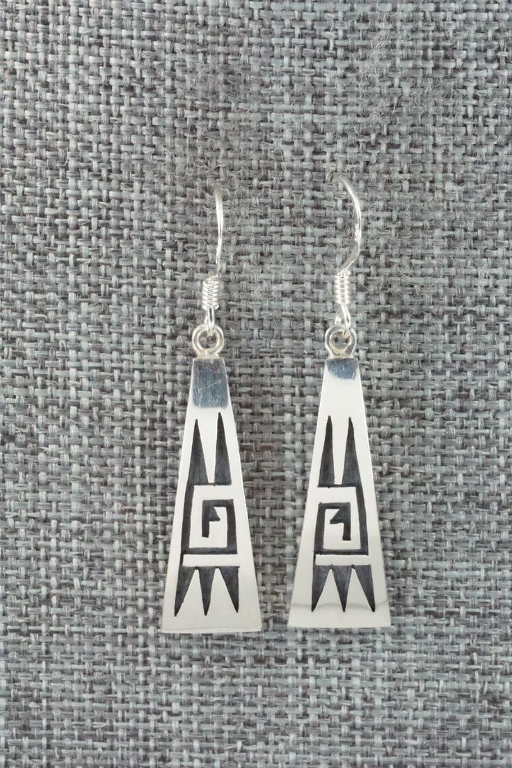 These sterling silver earrings were made by Hopi silversmith Augustine Mowa. The back is stamped sterling.Length: 1 1/2"Width: 3/8"Free shipping on all orders! We ship with USPS and always include tracking. All orders ship within a day of payment.Returns are accepted up to 30 days after you receive your order. Just send us a message. Our shop offers cash back or store credit. The item must be returned in new condition. Traditional Etched Silver Earrings, Traditional Silver Etched Earrings, Artisan Sterling Silver Etched Earrings, Artisan Etched Sterling Silver Earrings, Symbolic Sterling Silver Pierced Earrings, Symbolic Hallmarked Sterling Silver Earrings, Engraved Sterling Silver Dangle Earrings, Silver Engraved Symbolic Earrings, Silver Symbolic Engraved Earrings