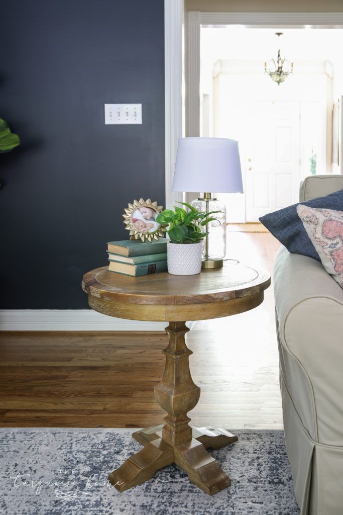 a living room with a couch, table and lamp on it's end table