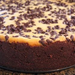 a chocolate cake with white frosting and chocolate chips on top