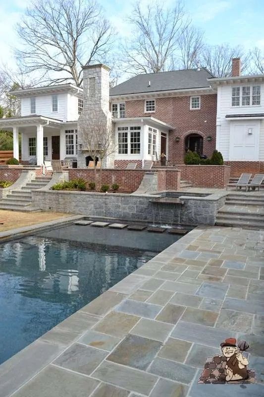 an outdoor swimming pool with steps leading up to it and a house in the background