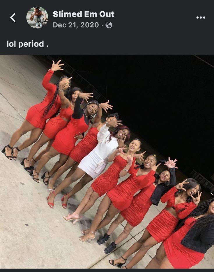 a group of women in red dresses posing for a photo