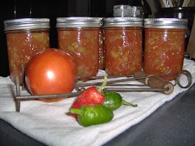 four jars filled with food sitting on top of a white towel next to a red pepper