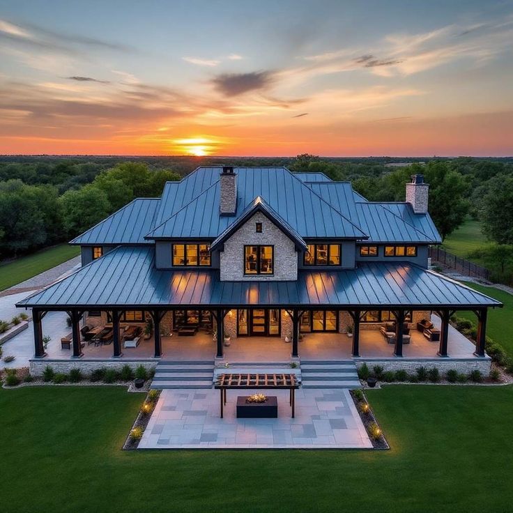 an aerial view of a large house at sunset