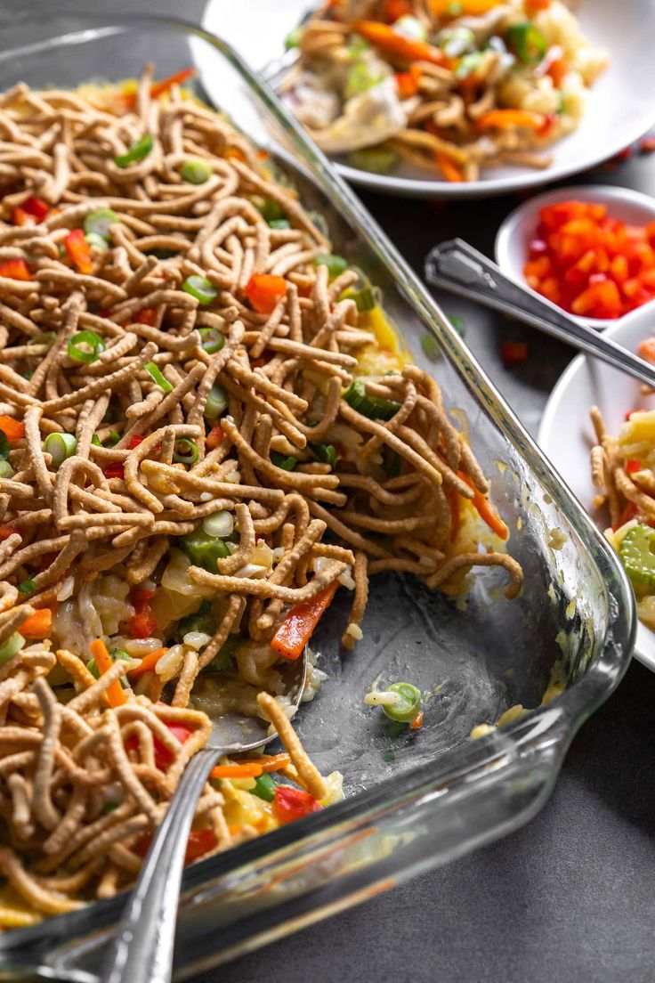 a casserole dish with noodles, carrots and celery on the side