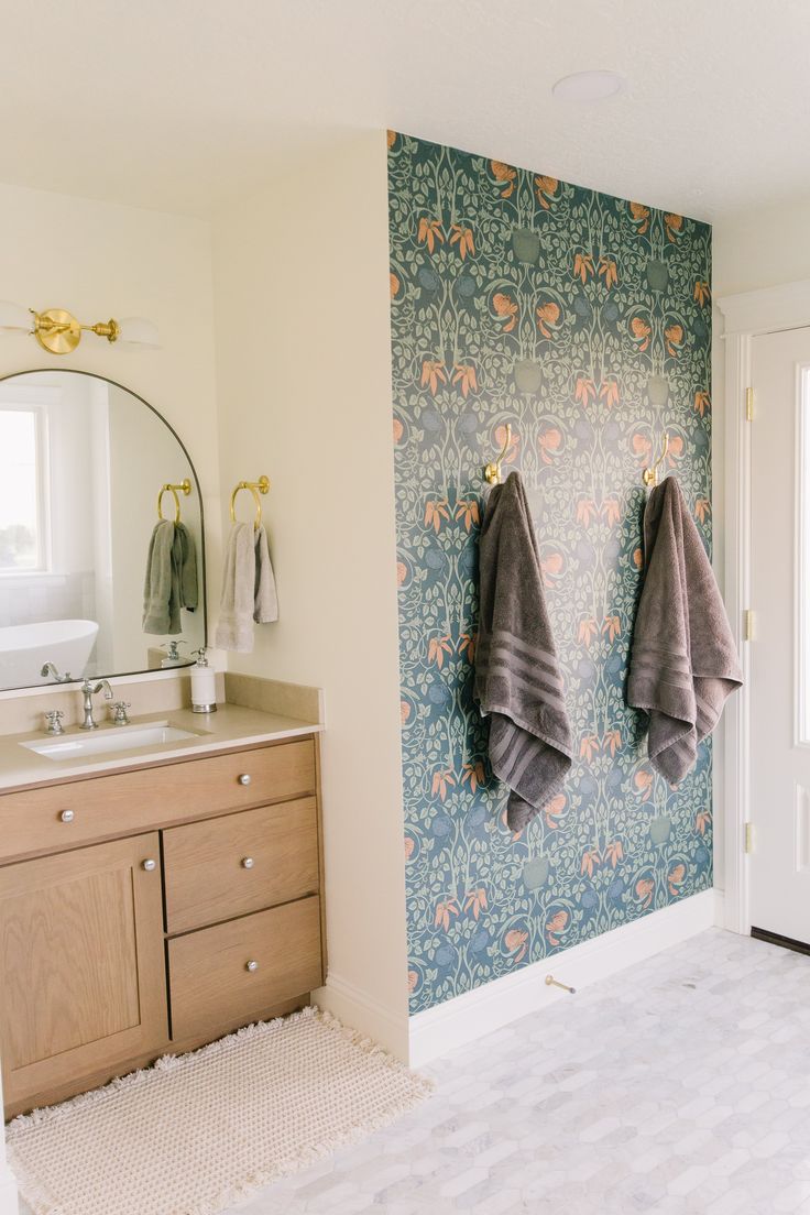 two towels are hanging on the wall next to a sink and mirror in a bathroom