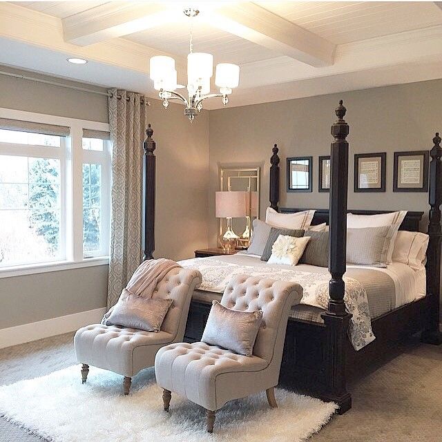 a bedroom with four poster bed, two chairs and a chandelier hanging from the ceiling