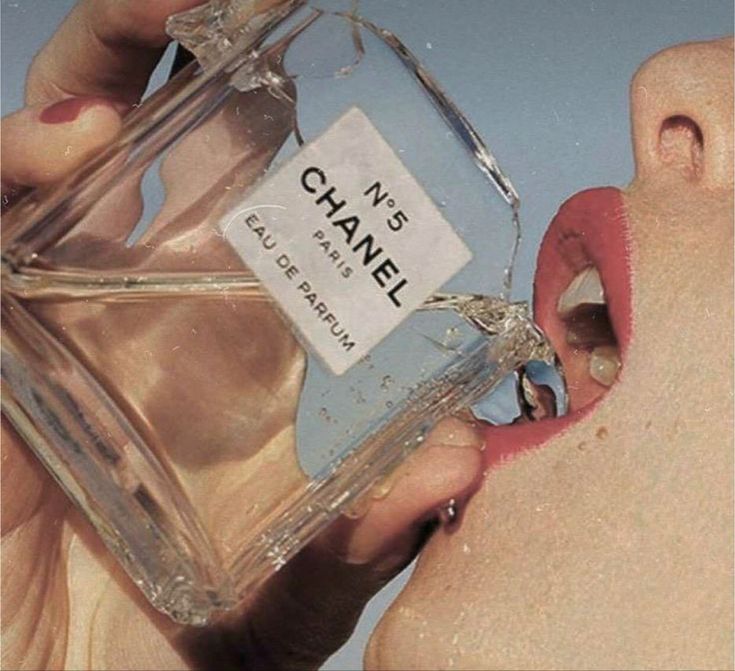 a person holding a bottle of chanel perfume