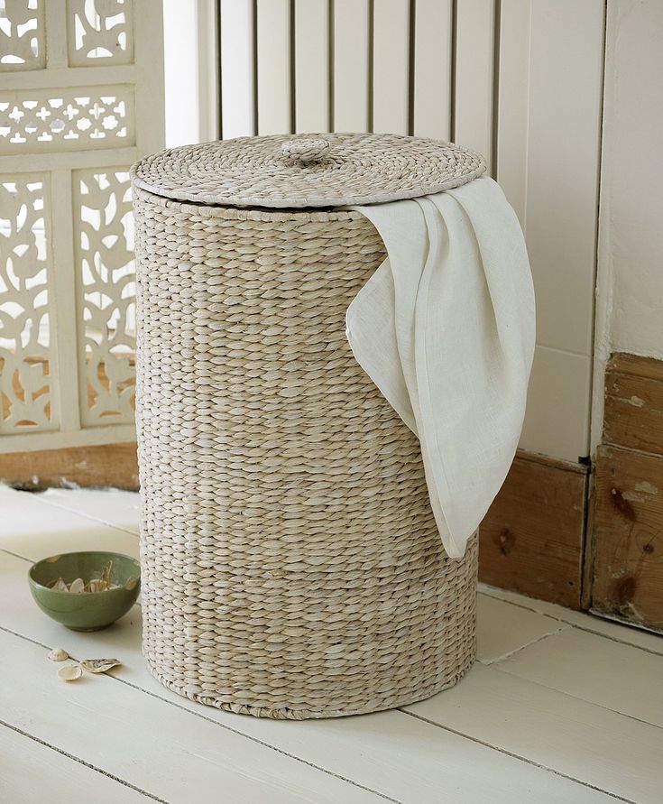 a wicker laundry basket with a white cloth on top