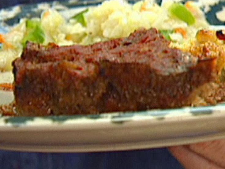 a person holding a plate with meat and vegetables on it in front of the camera