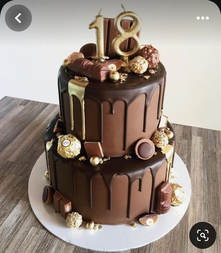 a three tier chocolate cake with gold decorations on the top and number eight on the bottom