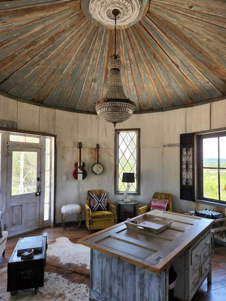 a room with a table, chairs and a ceiling fan in the middle of it