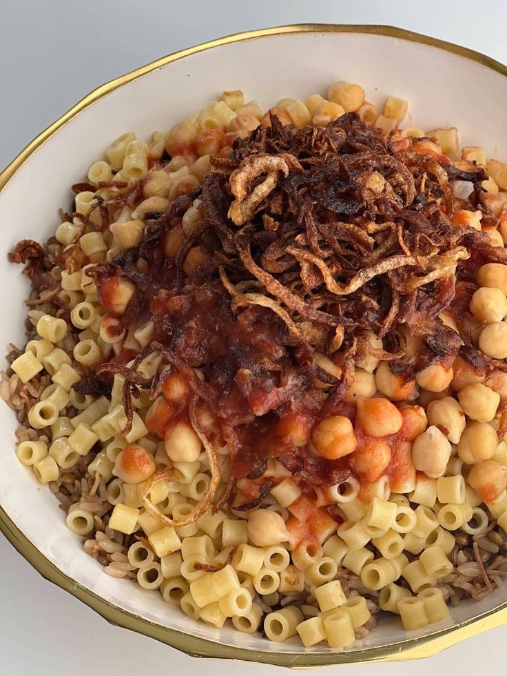 a white bowl filled with pasta and meat