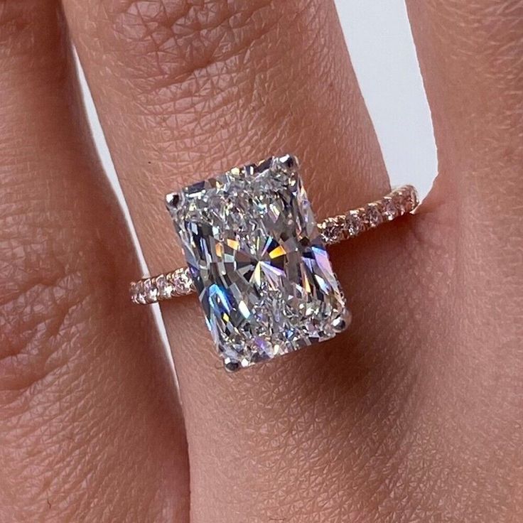 a woman's engagement ring with a cushion cut diamond in the center and pave band