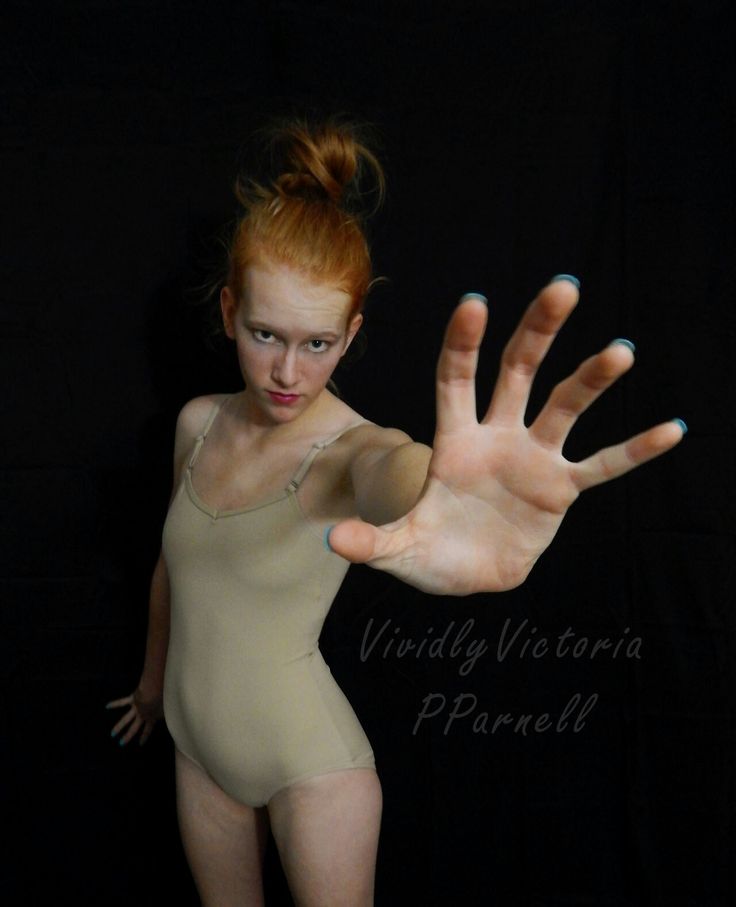 a woman in a bodysuit holding her hand out