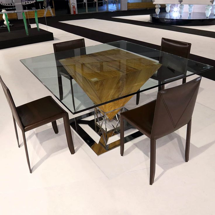 a glass table with chairs around it in the middle of an empty floored room