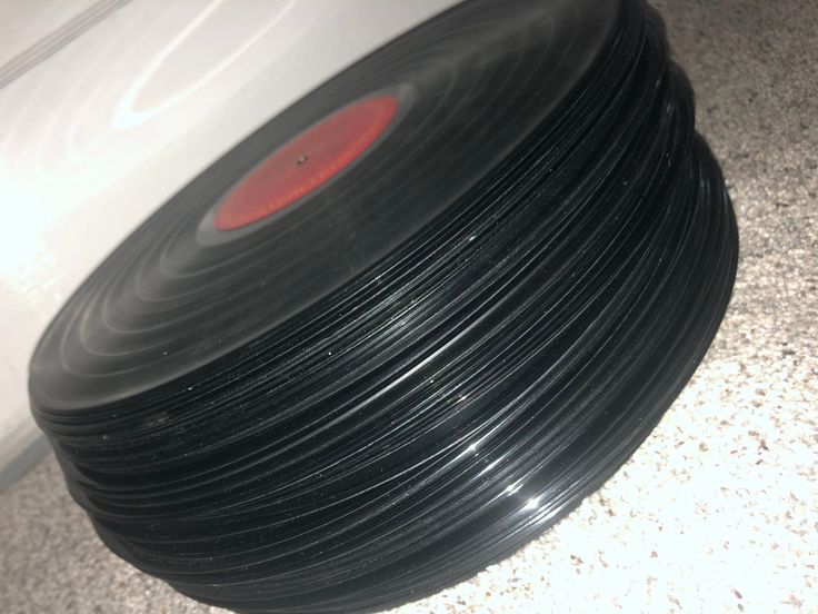 an old record sitting on the floor next to a white car with red light in it