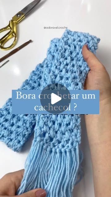 someone is crocheting a blue scarf with scissors