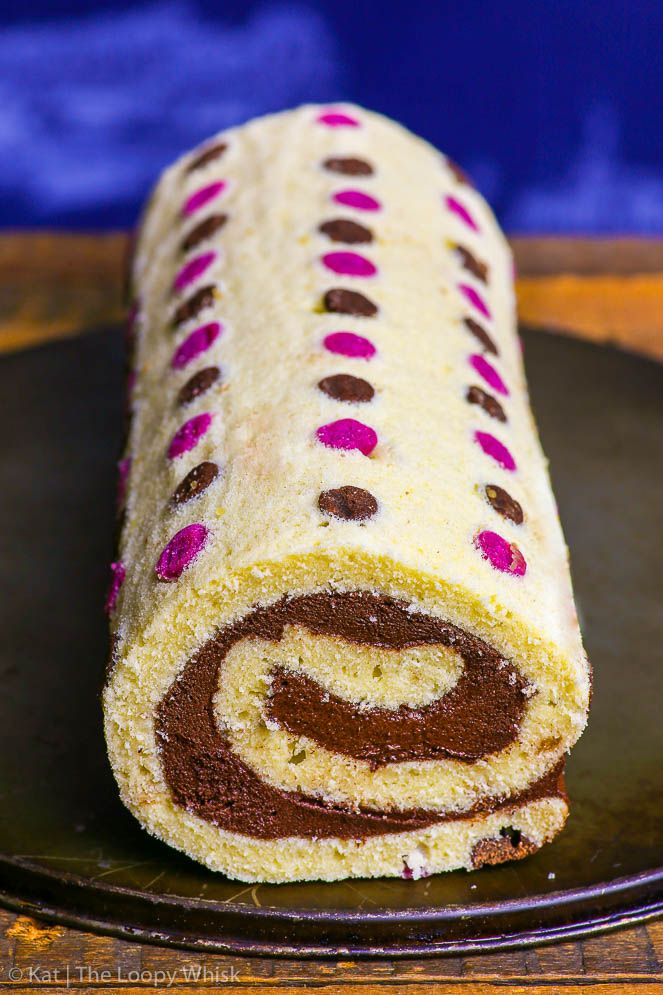 there is a roll that has been decorated with chocolate and pink polka dots on it