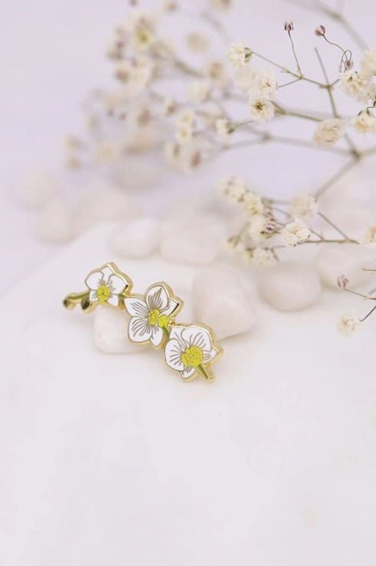 Orchids are gorgeous plants with magnificent foliage. This enamel pin would be spectacular when worn on a top, or affixed to a tie, hat, bag, scarf, purse or backpack. | White Orchid Pin | Plant Scouts Enamel Pin Collection, plant pins, plant pins and patches, plant enamel pins White Enamel Brooches As Gifts, White Flower Brooch As A Gift, White Flower Brooch For Gift, White Flower Brooch As Gift, White Flower Brooches For Gift, White Flower Pins For Wedding, White Flower-shaped Wedding Pins, White Flower Pins As Gifts, White Flower Pins For Gifts