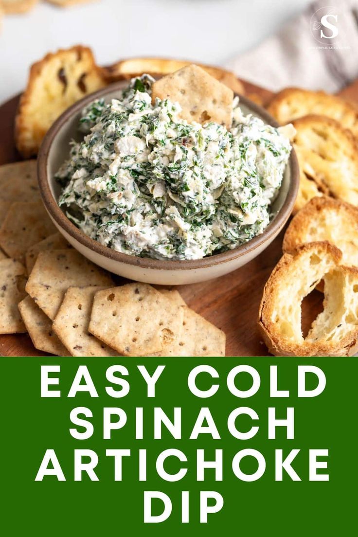 spinach artichoke dip in a bowl with crackers on the side