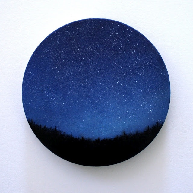 a blue and black plate sitting on top of a white wall