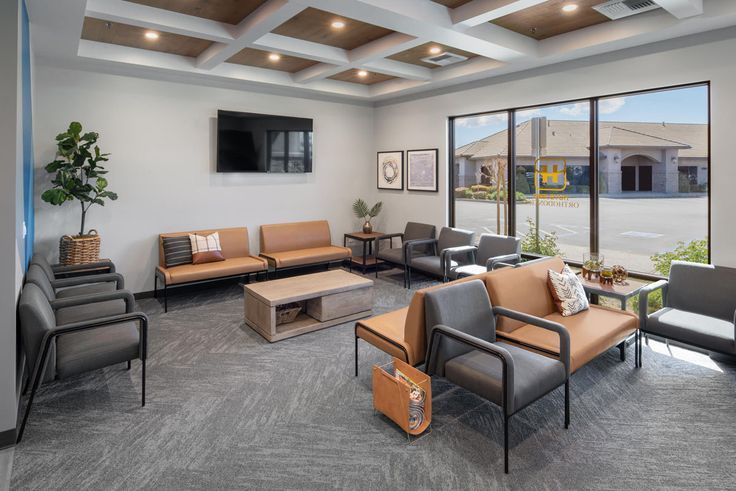 a waiting room with couches, chairs and television