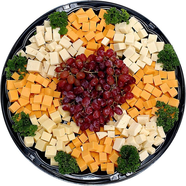 a platter with cheese, grapes and broccoli arranged in the shape of a heart