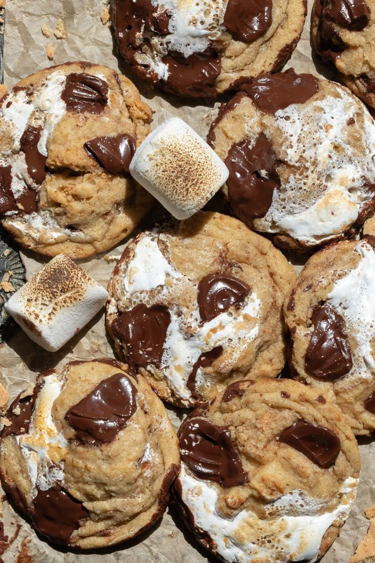 chocolate chip cookies with marshmallows and powdered sugar on top are shown