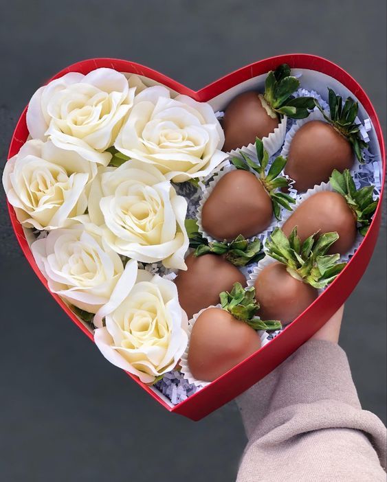 a heart shaped box filled with eggs and flowers