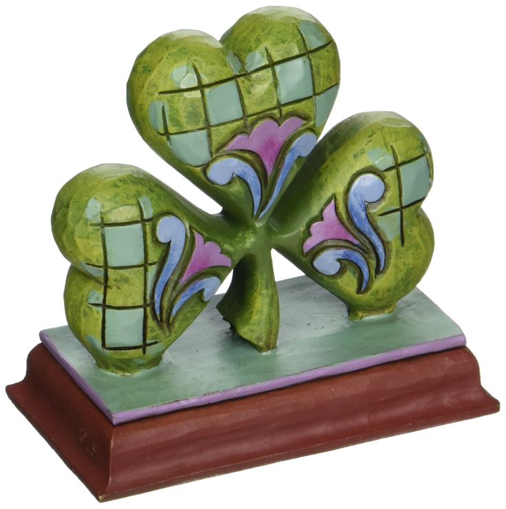 three hearts shaped like four leaf clovers on top of a wooden base with a white background