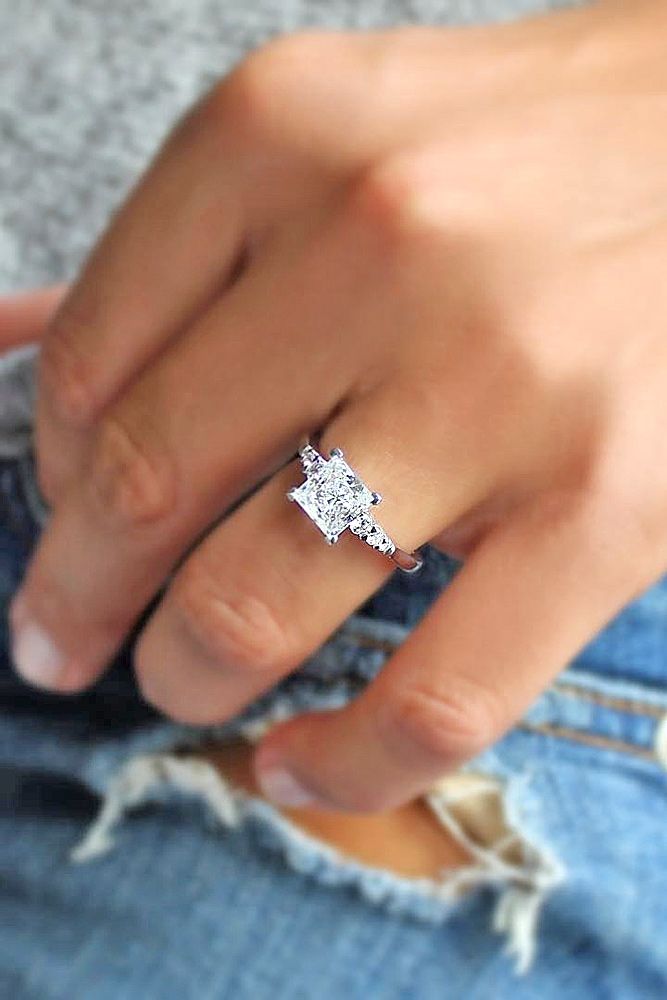 a person wearing a diamond ring on their finger