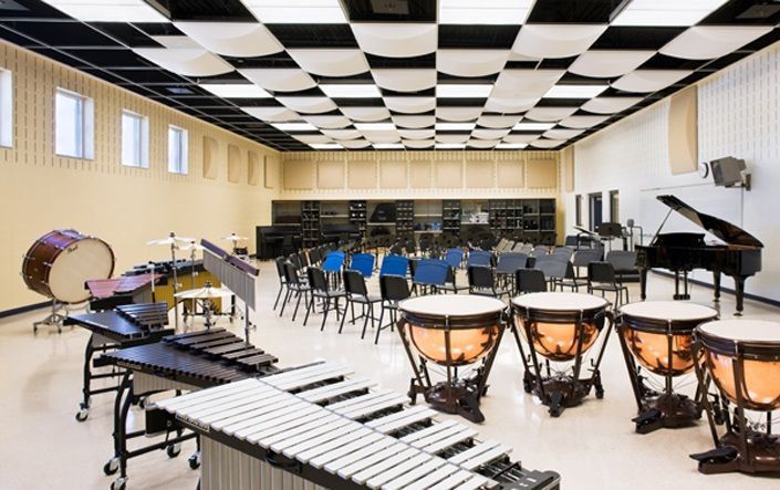 an empty room with many musical instruments and lights on the tables in front of them