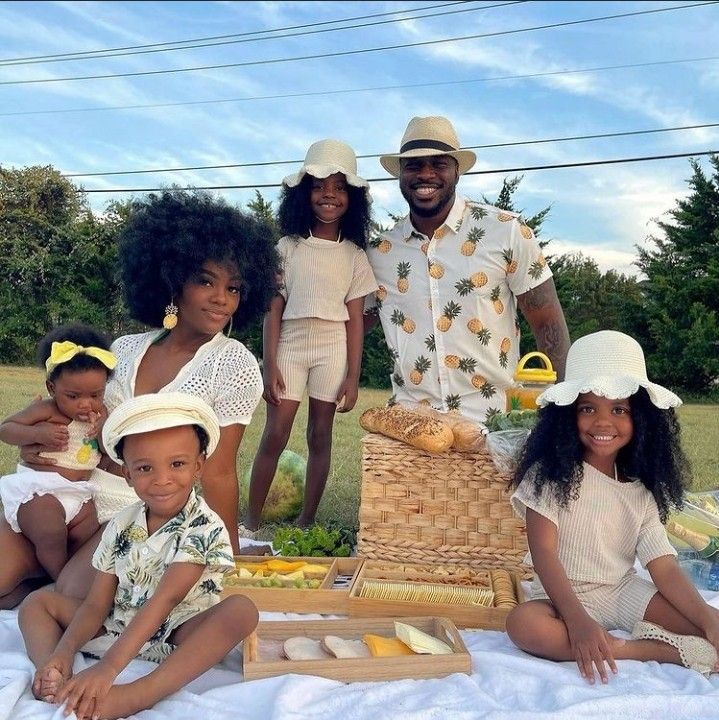 a family poses for a photo in front of a picnic basket