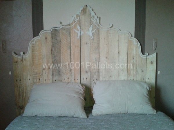 a bed made out of wood with two white pillows on top of the headboard