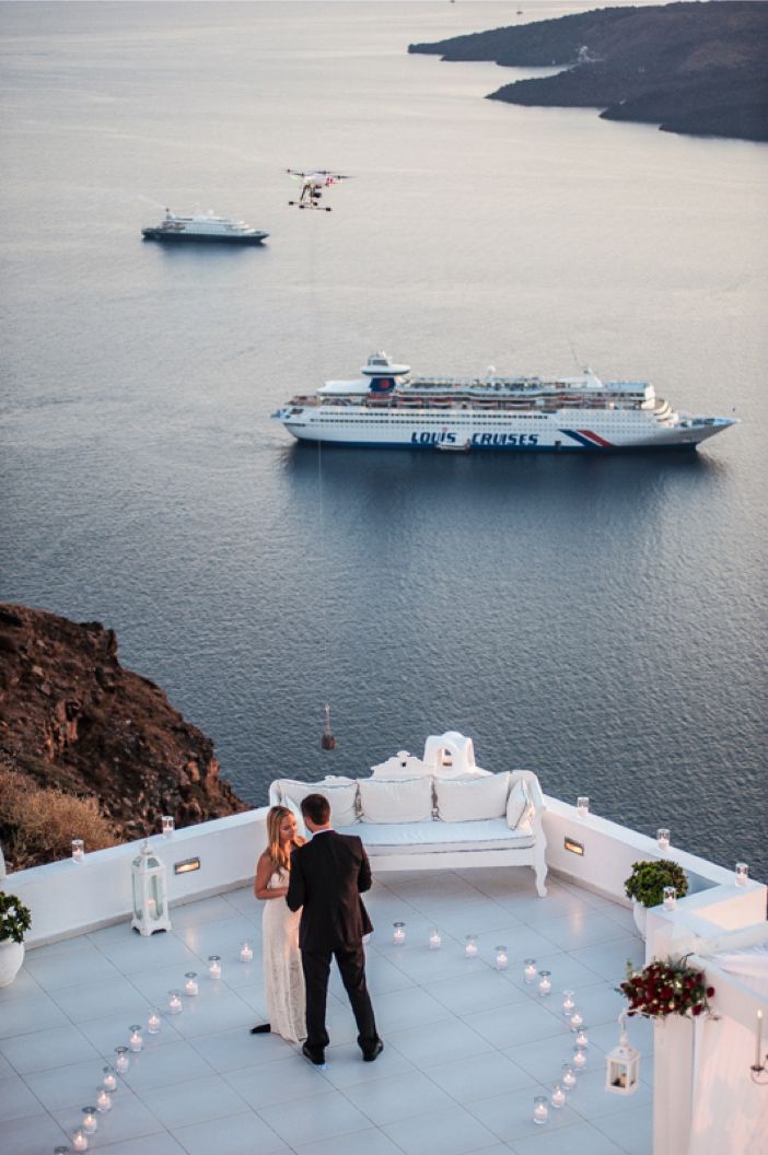 a man and woman standing on top of a roof next to a body of water