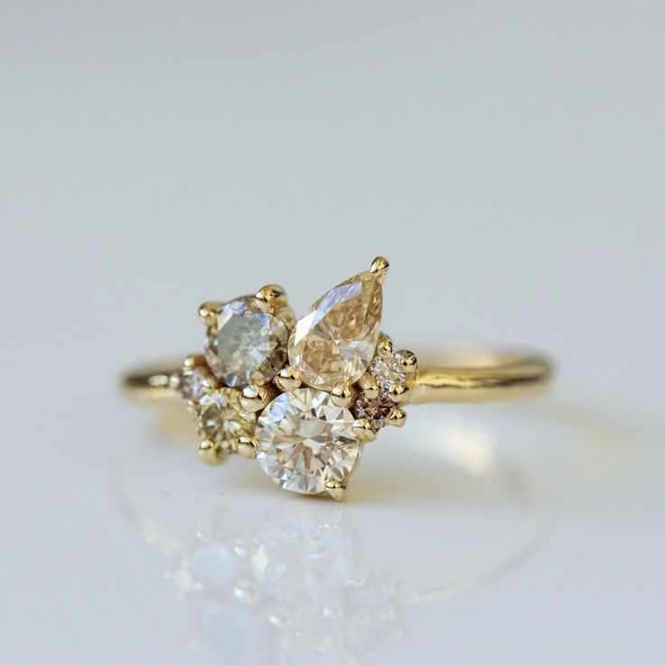 a yellow gold ring with three pear shaped diamonds