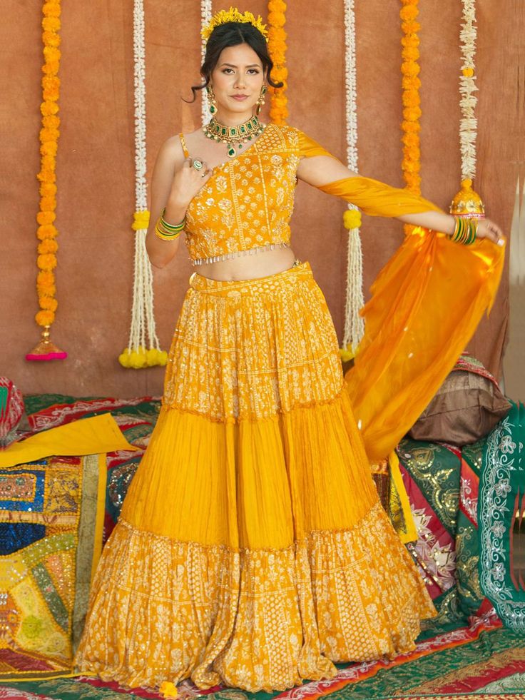 Enhance your beauty and make a statement with the Avantika Lehenga. This whimsical lehenga is designed to bring out your innate grace and grandeur. With its stunning mirror, pearl, stone, and embroidery work, this lehenga is perfect for women who want to shine at haldi ceremonies, special events, and festive occasions. Key Features: Color: Merigold Yellow Fabric & Work Style: Silk blouse with mirror, pearl, stone, and embroidery work Soft net lehenga with mirror, pearl, stone, and embroidery wor Semi-stitched Floor-length Pre-draped Saree With Gota Work, Festive Georgette Choli For Navratri, Dabka Work Sets For Reception And Navratri, Navratri Reception Palazzo Set With Gota Work, Floor-length Pre-draped Saree With Gota Work For Designer Wear, Designer Floor-length Pre-draped Saree With Gota Work, Bollywood Style Chinon Set For Navratri, Navratri Chandbali Shape Georgette Choli, Bollywood Chinon Set For Navratri