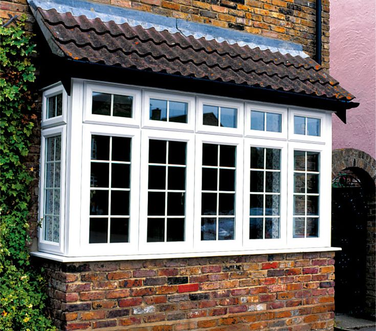 a brick house with white windows and tiled roof